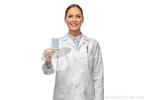 Image of smiling female doctor holding medicine pills