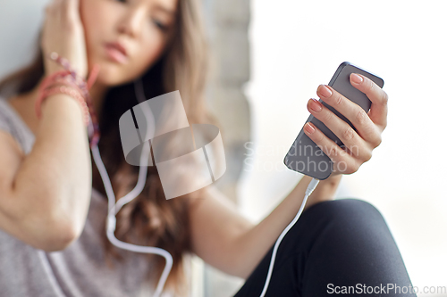 Image of teenage girl with smartphone and earphones