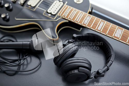 Image of close up of bass guitar, microphone and headphones