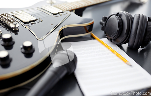 Image of close up of guitar, music book and headphones