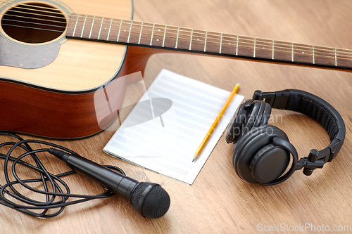 Image of guitar, music book, microphone and headphones