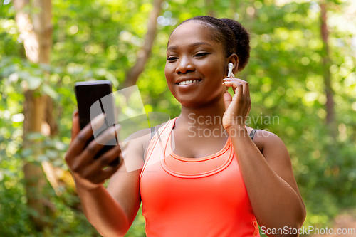 Image of african american woman with earphones and phone