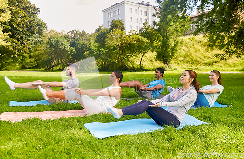 Image of group of people doing yoga at summer park