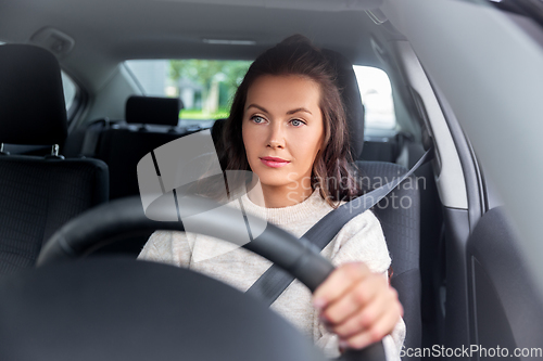 Image of woman or female driver driving car in city