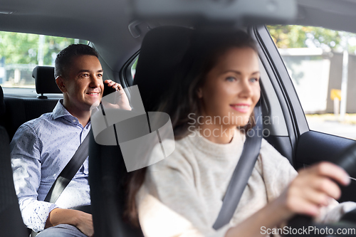 Image of male passenger calling on phone in taxi car