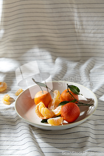 Image of still life with mandarins on plate over drapery