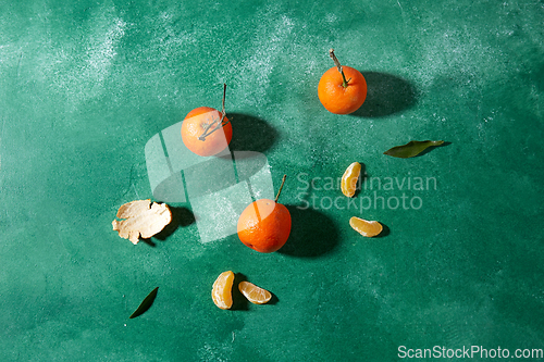 Image of still life with mandarins on green background