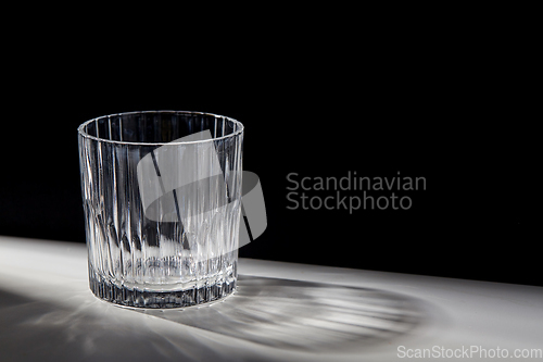 Image of empty faceted glass on table