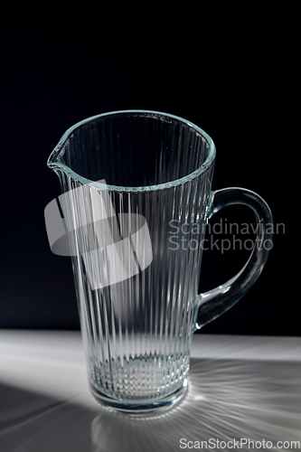Image of empty faceted glass jug on table
