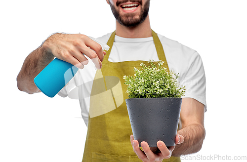 Image of happy gardener or farmer with sprayer and flower