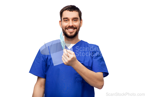 Image of smiling male doctor in blue uniform with mask
