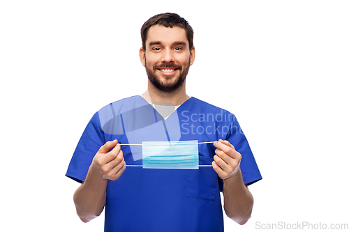 Image of smiling male doctor in blue uniform with mask