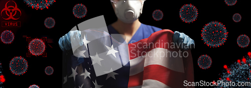 Image of doctor in goggles and mask holding flag of america