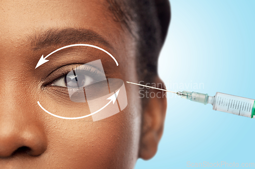 Image of close up of face of african woman and syringe