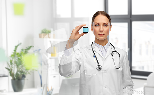 Image of female doctor holding jar of medicine at hospital