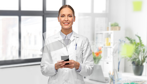 Image of happy female doctor with smartphone at hospital