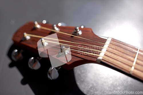 Image of close up of acoustic guitar head with pegs