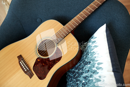Image of close up of acoustic guitar on armchair