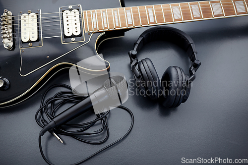 Image of close up of bass guitar, microphone and headphones