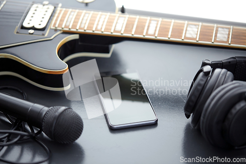 Image of close up of bass guitar and smartphone