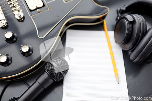 Image of close up of guitar, music book and headphones