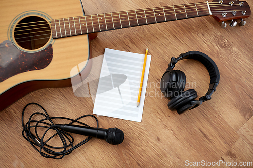 Image of guitar, music book, microphone and headphones