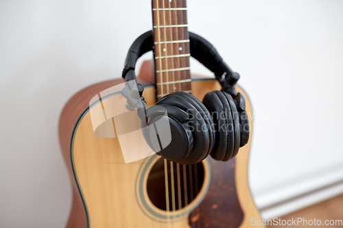 Image of close up of acoustic guitar and headphones