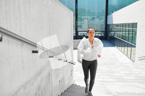 Image of african american woman running upstairs outdoors