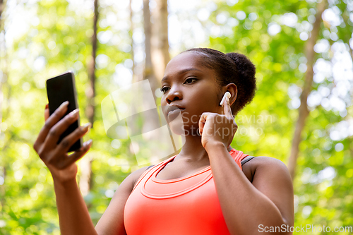 Image of african american woman with earphones and phone