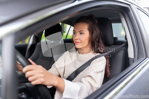 Image of woman or female driver driving car in city