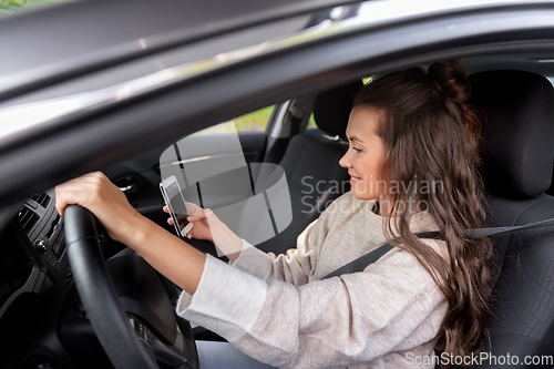 Image of smiling woman or female driver driving car in city