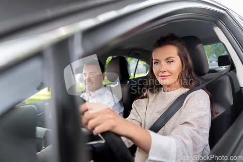 Image of woman and driving school instructor in car