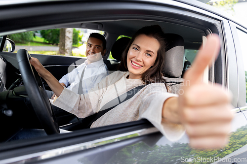 Image of car driving instructor and woman showing thumbs up