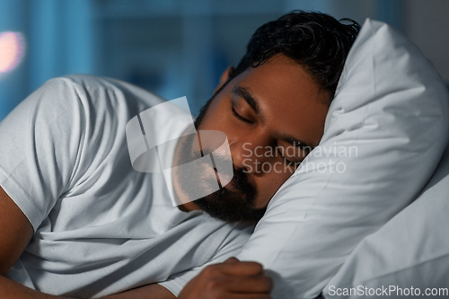 Image of indian man sleeping in bed at home at night