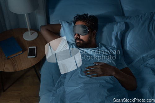 Image of indian man sleeping in bed at home at night