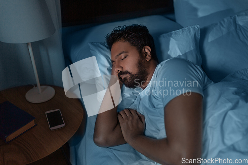 Image of indian man sleeping in bed at home at night