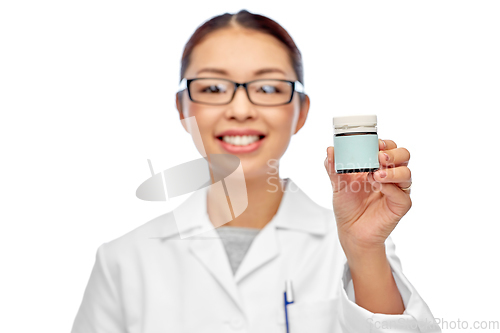 Image of smiling female doctor holding jar of medicine