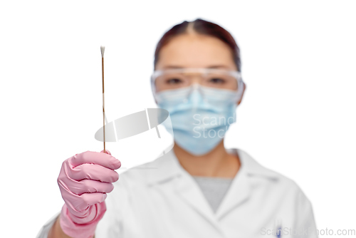 Image of asian female doctor in mask with test cotton swab