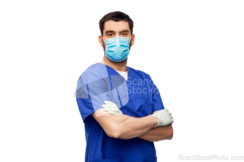 Image of male doctor in blue uniform, mask and gloves