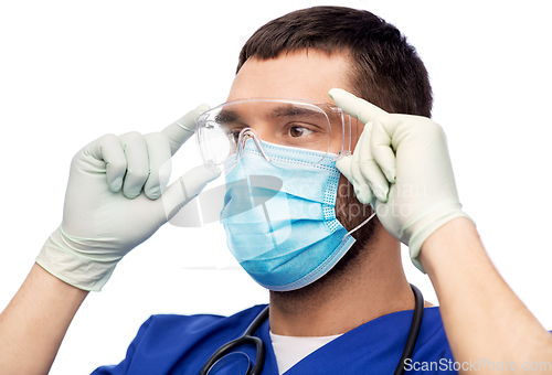 Image of male doctor in goggles, mask and gloves