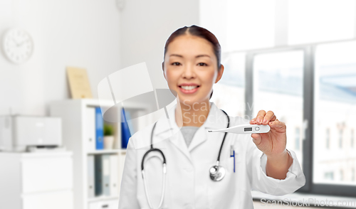 Image of smiling asian female doctor with thermometer