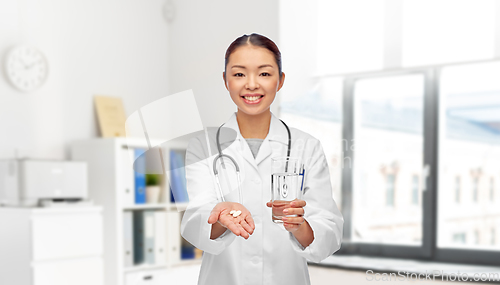 Image of asian doctor with medicine and glass of water