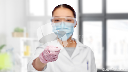 Image of asian female doctor in mask with test cotton swab