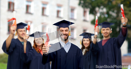 Image of male graduate student in mortar board with diploma