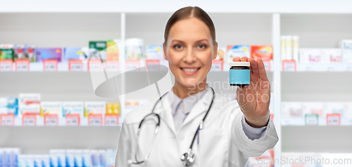 Image of smiling female doctor with medicine at pharmacy