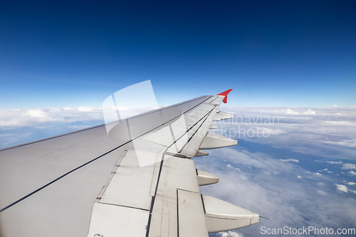 Image of Wing of an airplane flying above the clouds.