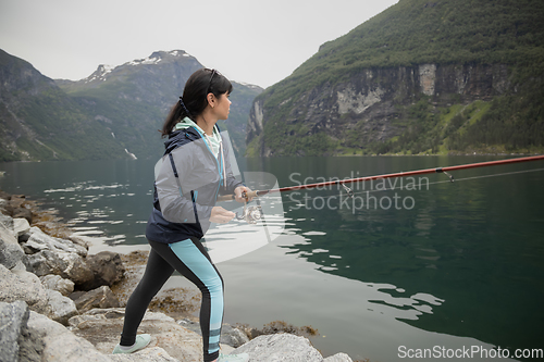 Image of Woman fishing on Fishing rod spinning in Norway.