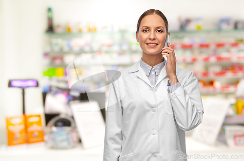 Image of female doctoror calling on smartphone at pharmacy