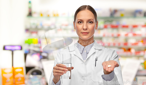 Image of female doctor with medicine and glass of water