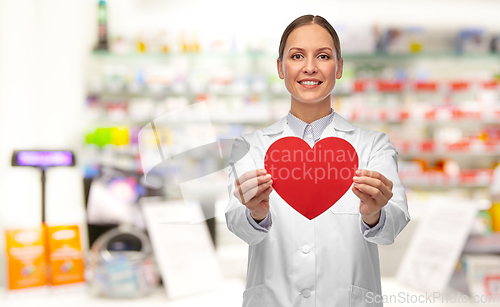 Image of smiling female doctor with heart at pharmacy